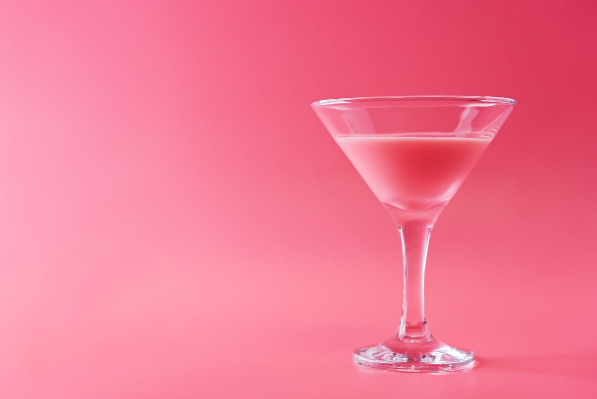 Pink cocktail in a glass on a pink background